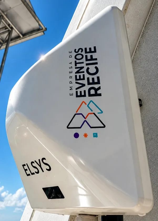 Modem 5G Elsys branco instalado em mastro, com o cabo de rede saindo pela base